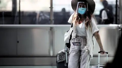 Una pasajera caminando con maleta por un pasillo de la terminar T4 del Aeropuerto Adolfo Su&aacute;rez Madrid Barajas, en Madrid (Espa&ntilde;a), a 24 de julio de 2020. 