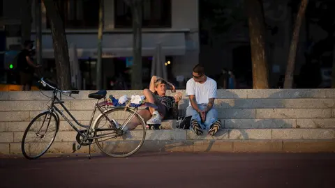 Dos j&oacute;venes junto a una bicicleta en Barcelona, Catalunya (Espa&ntilde;a), a 28 de julio de 2020.