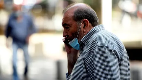 Un hombre con mascarilla habla por tel&eacute;fono en la calle, en Madrid (Espa&ntilde;a) a 30 de julio de 2020.