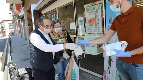 Reparto a dos clienes de mascarillas a la puerta de un Supermercado en Algete (Madrid)  
