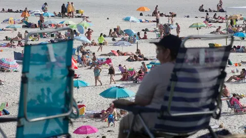 Una persona sentada frente a la playa en A Mari&ntilde;a (Lugo/Galicia) a 27 de julio de 2020. La comarca mantiene este domingo 51 casos activos de COVID-19 tras una nueva alta y un nuevo contagio con respecto al s&aacute;bado.
