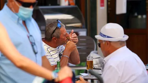 Personas fumando en terrazas y v&iacute;as p&uacute;blicas  durante el d&iacute;a en el que se ha decretado la prohibici&oacute;n de fumar en espacios p&uacute;blicos si no se respeta la distancia de seguridad establecida. M&aacute;laga a 14 de agosto del 2020