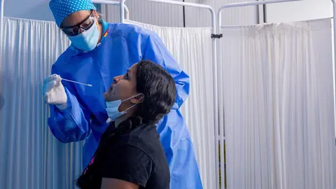 Un trabajador sanitario protegido le realiza a una mujer un test PCR en el Centro de Especialidades Carabanchel Alto. En Carabanchel, Madrid, (Espa&ntilde;a), a 17 de agosto de 2020.