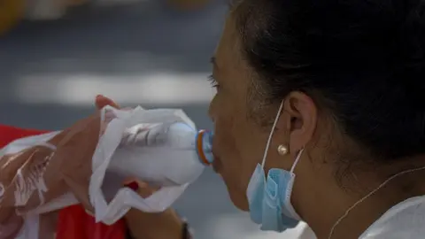 Una mujer bebiendo agua durante la ola de calor africano del pasado 30 de julio de 2020.