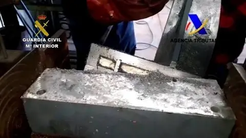 Agentes de la Guardia Civil muestran un fragmento de las troqueladoras procedentes de Colombia donde estaba oculta la droga.