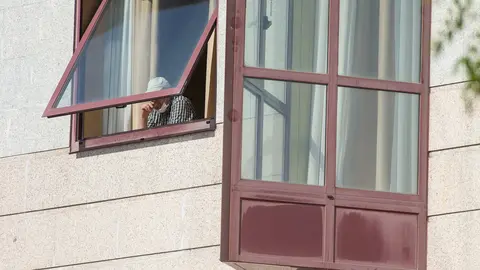 Una persona se asoma por la ventana de una residencia de mayores 