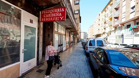 Una mujer pasea por las calles del barrio La Inmobiliaria de Torrelavega