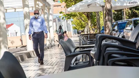 Una persona camina junto a una terraza de un bar vac&iacute;a del barrio de Valdepasillas, perteneciente a la zona de salud de La Paz, una de las que m&aacute;s contagios experimenta en Badajoz, Extremadura (Espa&ntilde;a), a 21 de septiembre de 2020.
