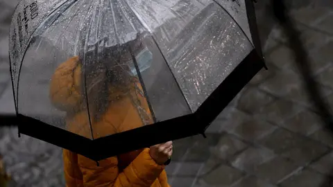 Una persona camina bajo la lluvia protegida con un paraguas, en Madrid (Espa&ntilde;a) a 24 de septiembre de 2020. La ciudad ha registrado un chubasco intenso este jueves entre las 08.30 y las 10.00 horas en el que se han acumulado entre 17 y 19 litros por metro