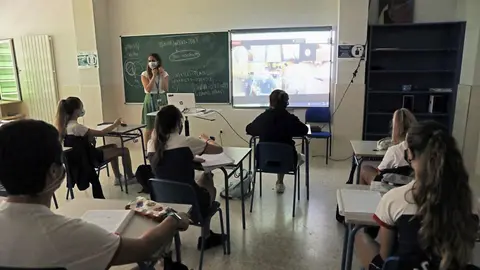 Una profesora y alumnos en una clase.
