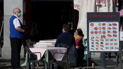 Un camarero atiende la terraza de un establecimiento ubicado en la Plaza Mayor durante el primer d&iacute;a con nuevas restricciones en la movilidad, en Madrid, (Espa&ntilde;a), a 3 de octubre de 2020.