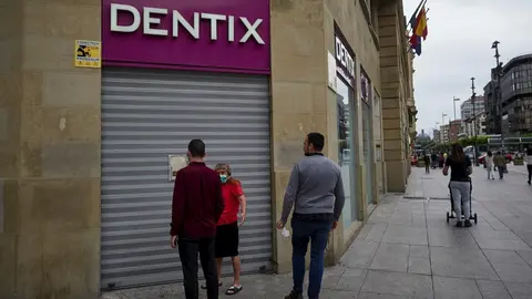 Una mujer se apoya en la puerta de una cl&iacute;nica Dentix para conocer si est&aacute; abierta . En Pamplona, Navarra (Espa&ntilde;a), a 25 de mayo de 2020.