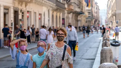 Una familia pasea con mascarilla por Roma