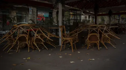 Sillas recogidas de una terraza de un bar cerrado 
