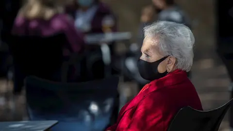 Una mujer mayor con mascarilla en la terraza de un bar. En Sevilla (Andaluc&iacute;a, Espa&ntilde;a), a 23 octubre de 2020.