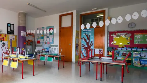 Mesas y sillas recogidas en un aula 