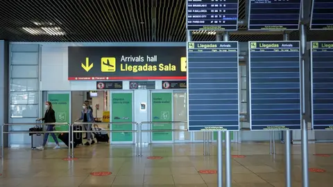 Personas abandonan una de las salidas de la sala de llegadas de la Terminal 1 del Aeropuerto de Barajas.