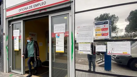 Una mujer sale de una oficina de empleo