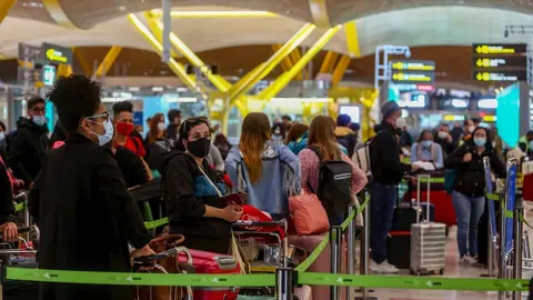Filas de pasajeros esperan para dejar su maleta antes de embarcar en el avi&oacute;n en la T4 del Aeropuerto Adolfo Su&aacute;rez Madrid-Barajas, en Madrid, (Espa&ntilde;a).