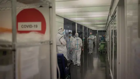 Varios sanitarios protegidos en la Unidad de Cuidados Intensivos de un hospital.