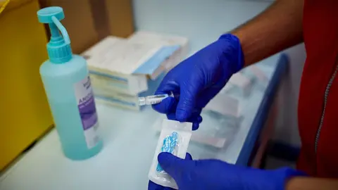 Un sanitario de Cruz Roja se prepara para administrar la vacuna contra la gripe