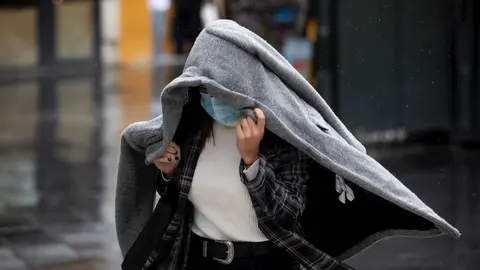 Foto de archivo. Una persona se protege de la lluvia con un abrigo.