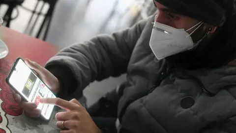 Un joven consulta las ofertas de Black Friday de un comercio en su m&oacute;vil, en Madrid (Espa&ntilde;a), a 15 de noviembre de 2020. Debido a las dificultades para comprar en los establecimientos f&iacute;sicos impuestas por la pandemia, en el Black Friday de 2020 las cifra