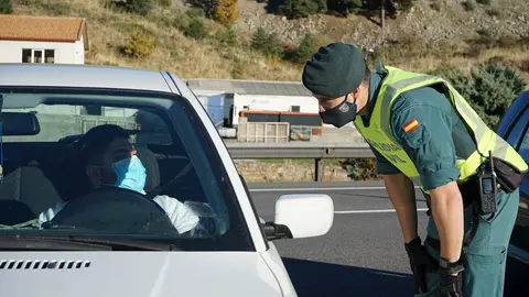 Un agente de la Guardia Civil le pide la documentaci&oacute;n al conductor de un veh&iacute;culo durante un control de movilidad en la carretera AP-6 de acceso a Segovia, Castilla y Le&oacute;n, (Espa&ntilde;a), a 30 de octubre de 2020.
