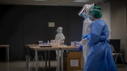 Profesionales sanitarios en un dispositivo de cribados masivos en el barrio del Raval, en Barcelona (Espa&ntilde;a)