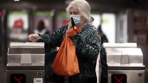 Una anciana con un billete en los torniquetes del metro de Oporto, Madrid (Espa&ntilde;a), a 17 de noviembre de 2020.