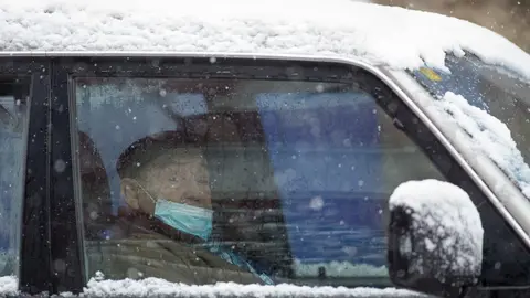 Un anciano con mascarilla permanece en su veh&iacute;culo durante la nevada en Becerrea, en Lugo, Galicia (Espa&ntilde;a), a 4 de diciembre de 2020.