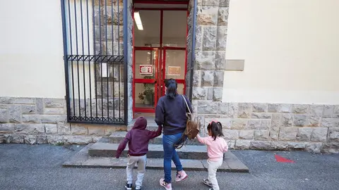 Una madre lleva a sus hijos al Colegio.