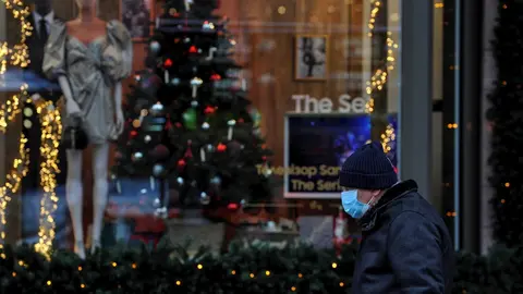 Un hombre con mascarilla ante un escaparate en Kiev