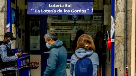 Varias personas hacen cola en las inmediaciones de la administraci&oacute;n de loter&iacute;a Sol donde venden boletos para el Sorteo Extraordinario de la Loter&iacute;a de Navidad 2020, en Madrid (Espa&ntilde;a), a 4 de noviembre de 2020. A un mes y medio del tradicional sorteo, la