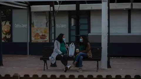 Dos mujeres charlan sentadas en un banco, en Barcelona, Catalunya (Espa&ntilde;a), a 21 de diciembre de 2020.