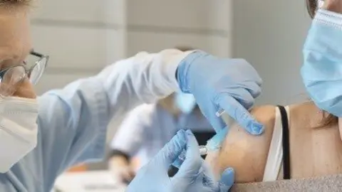 Una enfermera pone una vacuna