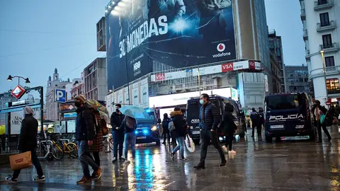 Transe&uacute;ntes caminan cerca de una zona comercial en la calle de Preciados, en Madrid (Espa&ntilde;a)