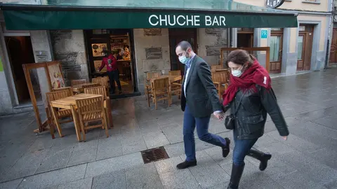 Dos personas pasan frente a una terraza en en Lugo, tras el levantamiento del cierre perimetral de la ciudad, en Lugo, Galicia (Espa&ntilde;a), a 30 de diciembre de 2020.  Lugo y Ourense ser&aacute;n las dos &uacute;nicas urbes gallegas sin cierre perimetral en Fin de A&ntilde;o, de