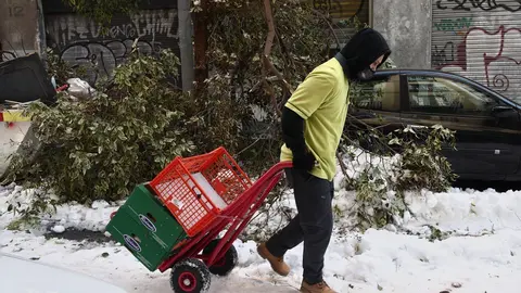 Un hombre arrastra una carretilla por una calle del centro a&uacute;n con nieve y &aacute;rboles ca&iacute;dos en Madrid (Espa&ntilde;a), a 13 de enero de 2021. Madrid sigue cubierto de nieve cinco d&iacute;as despu&eacute;s de la gran nevada provocada por el paso de la borrasca &lsquo;Filomena&rsquo;. El Ay