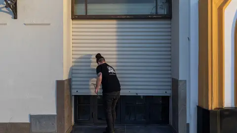 Un hostelero echa la persiana de su establecimiento