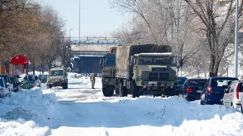 Un cami&oacute;n de la Unidad Militar de Emergencias (UME) colabora en la retirada de nieve y hielo en las inmediaciones del colegio Fuente de la Villa tras la gran nevada provocada por la borrasca 'Filomena', en Valdemoro (Madrid)