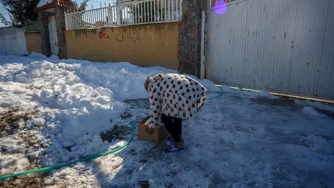 Una vecina de la Ca&ntilde;ada Real con una caja de bienes de primera necesidad de Cruz Roja.
