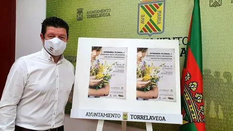 El concejal de Dinamizaci&oacute;n Social de Torrelavega, Jes&uacute;s S&aacute;nchez, junto al carte de la ofrenda floral a los fallecidos del Covid