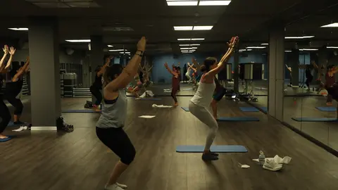 Un entrenador imparte clase a varias personas en una clase de Body Balance en un gimnasio de la cadena O2 en Madrid (Espa&ntilde;a)