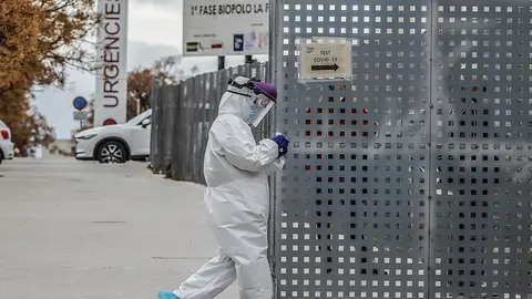 Un sanitario a los alrededores de la fila de veh&iacute;culos para realizarse una prueba PCR de detecci&oacute;n del coronavirus a las puertas del Hospital de Campa&ntilde;a pr&oacute;ximo al de La Fe, en Valencia.