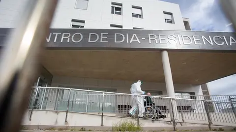 Un trabajador sanitario traslada a un anciano de una residencia en Lugo.