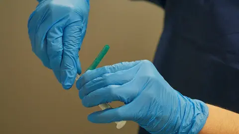 Una trabajadora sanitaria manipula el material necesario para administrar la vacuna contra la COVID-19