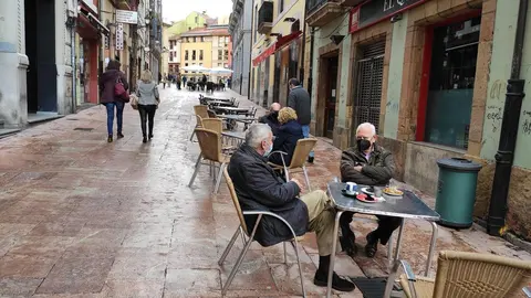 Terrazas de hosteler&iacute;a en Oviedo con personas con mascarilla en las mesas.