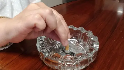 Apagando un cigarrillo. Cenicero. Tabaco. 
