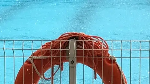 Piscina con un salvavidas naranja